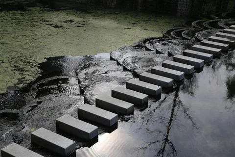 A series of interconnected, flat rectangular concrete blocks floating on th.. Stock Photos