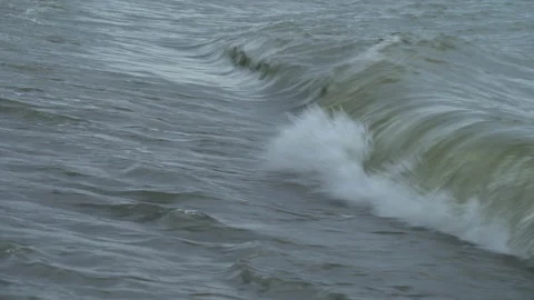 A series of small waves crash on a beach Stock Footage 132585460