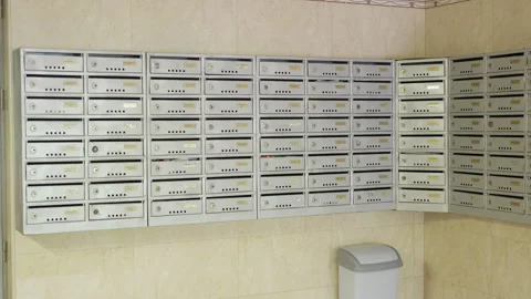 Series of three frames showing a row of silver mailboxes arranged in a corner of Stock Footage 340275199