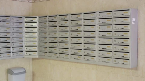 Series of three frames showing a row of gray mailboxes in a hallway, with a Stock Footage 340900829