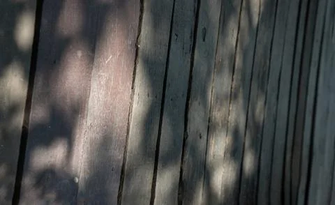 A series of weathered, vertically oriented wooden planks forms a textured sur Stock Photos