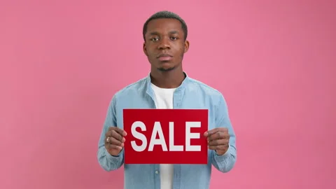 Serious African American man in white T-shirt and denim shirt advertises big Stock Footage