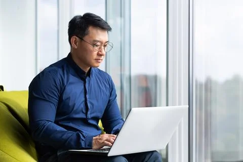 Serious and focused engineer developer programmer writing code using laptop at 스톡 사진