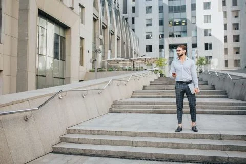 Serious and handsome young man stand and pose. He looks to right. Businessman Stock Photos