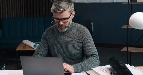 Serious and thoughtful Man working at his Office Room and typing on the Laptops Stock Footage 126243763