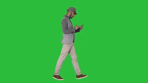 Serious arabic casual man using smartphone while walking on a Green Screen Video stock 115030039