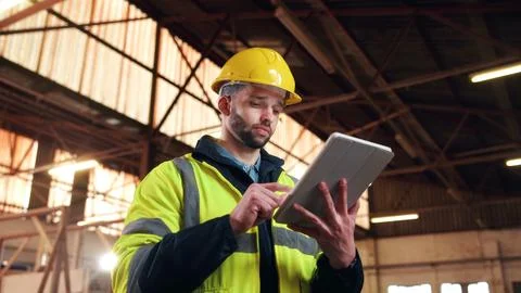 Serious, architect and man with tablet on construction site, online or plan.. Stock Photos