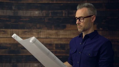 Serious architect reading engineer blueprint Stock Footage 85440830