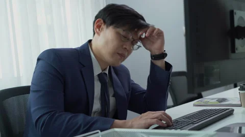Serious asian business man using computer on desk in office Stock Footage 252824092