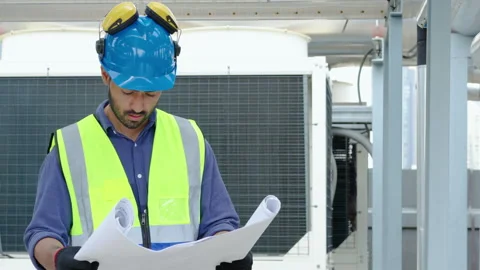 Serious asian guy engineer in uniform is checking construction plan or blueprint Stock Footage 280490109