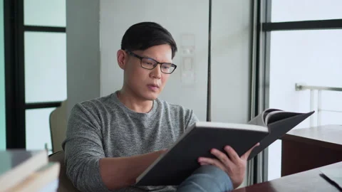 Serious asian young man Read a book Distraction Until having to stop reading Stock Footage 136957148