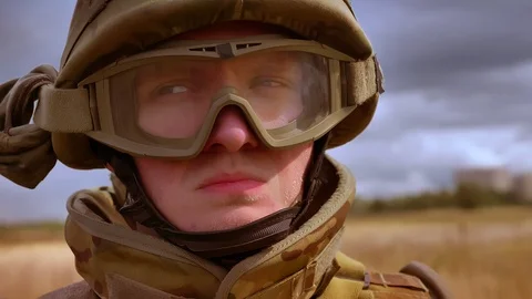 Serious assertive face in helmet of caucasian soldier standing still and looking Stock Footage 97728534