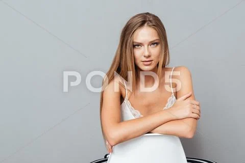 Serious attractive woman sitting on the chair Stock Photos