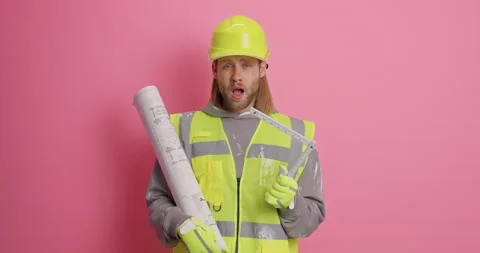 Serious bearded ginger man wears helmet uniform holds tape measure and blueprint Stock Footage 156632233