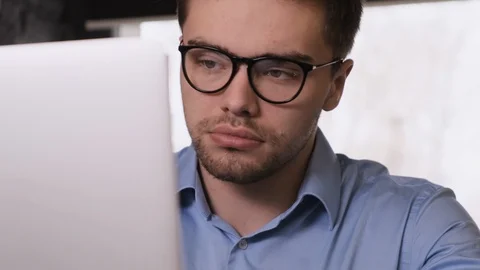 Serious bearded guy with glasses working n laptop Stock Footage 104144109