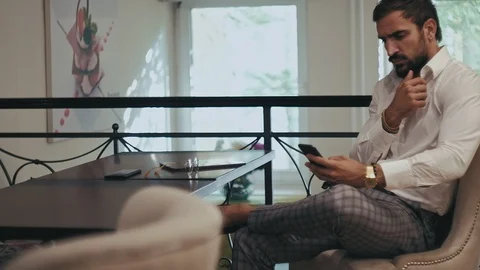 Serious bearded man using mobile phone in a cafe Stock Footage 96299955