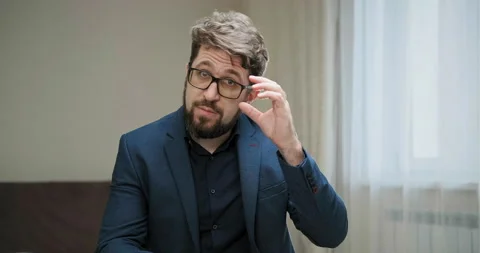 Serious bearded tutor looks to computer camera gives lesson Видео 146203912