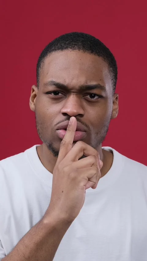 Serious Black Man Making a Shush Gesture on a Red Background Stock Footage 328126217