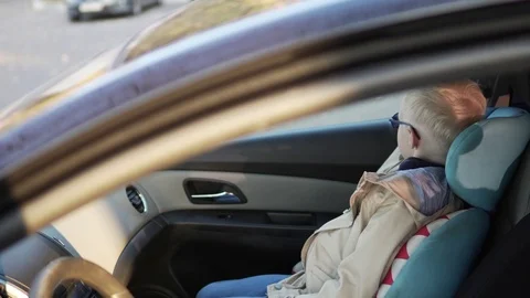 Serious blond boy clips on in the car. Stock Footage 96991278