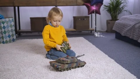 Serious boy learning to play remote control toy Stock Footage 85103226