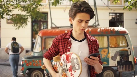 Serious boy using a mobile phone keeps skate guy business fashion hand child man Stock Footage 92050467