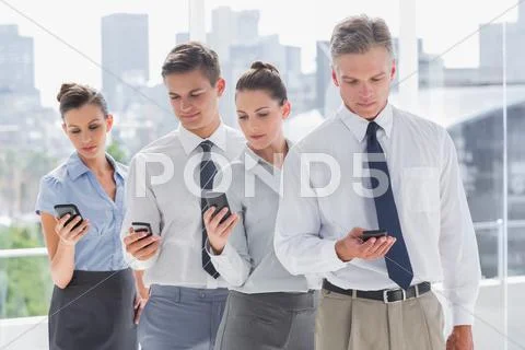 Serious business people standing together in line with their mobile Stock Photos