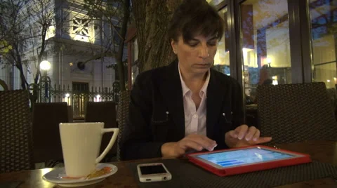Serious business woman using a tablet computer on a cafe terrace, typing Vídeos de archivo 32503070