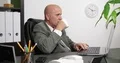 Serious Businessman Drink Coffee and Work on Laptop in Office Room 4k or 4k+ Resolution