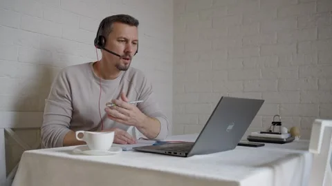 Serious Businessman in Headset Taking Notes During Online Seminar at Home. .. Video stock 331971398