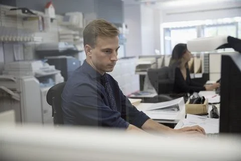 Serious businessman using computer in office cubicle Foto stock