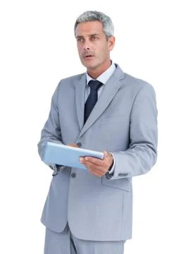 Serious businessman using tablet pc looking away Stock Photos