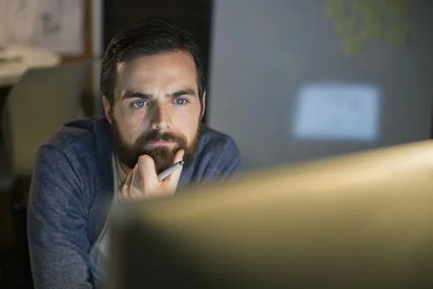 Serious businessman working late at computer in office Stock Photos