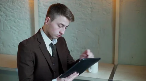 Serious Businessman working on tablet computer in the cafe and looking at camera Stock-Footage 56893152