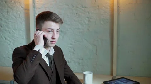 Serious Businessman working on tablet computer in the cafe and talking phone Stock-Footage 56893677