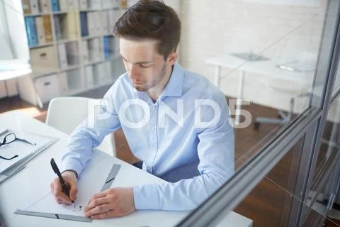 Serious businessman writing plan of working day by desk Stock Photos