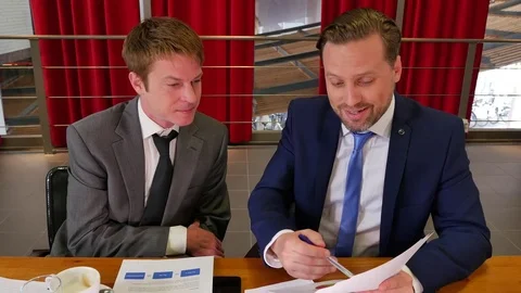 Serious businessmen analyzing documents with his colleague Video stock 74612580
