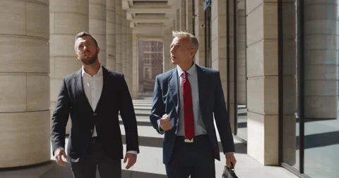 Serious businessmen partners dressed in formal suit walking and having Stock Footage 156448341