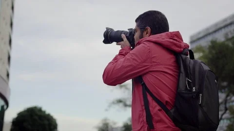 Serious calm man looking around and then taking picture. Stock Footage 100138098
