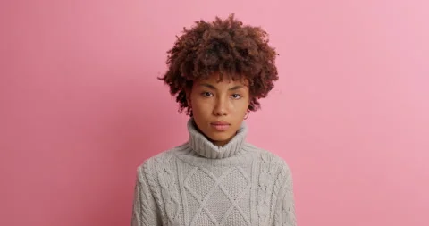 Serious calm young Afro American woman with curly hair looks confident at camera Stock Footage 142747553
