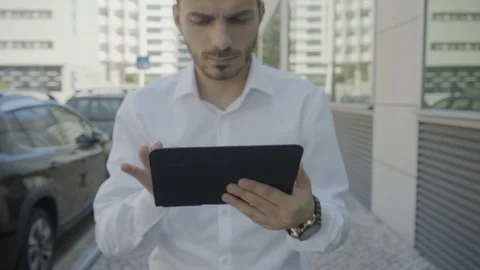 Serious Caucasian manager working on tablet and walking Stock-Footage 97922264