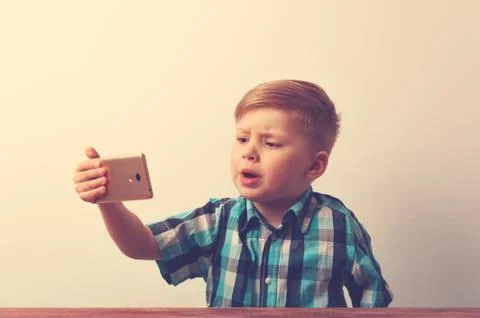 Serious caucasin child using smartphone Stock Photos