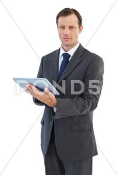 Serious charismatic businessman holding a tablet computer Stock Photos