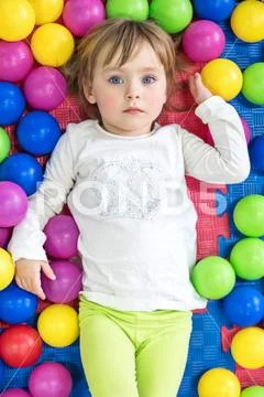Serious child in colorful balls Stock Photos
