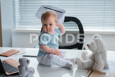 Serious child locating on desk Stock Photos
