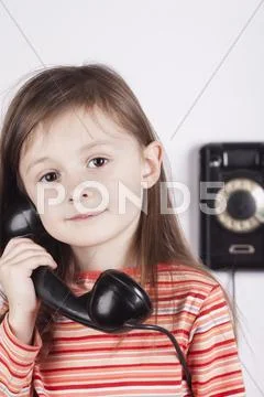 Serious child talking on phone, white background Stock Photos