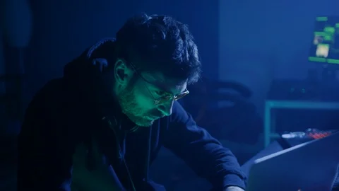 Serious computer hacker breaking into company database stealing data using Stock Footage 108820753