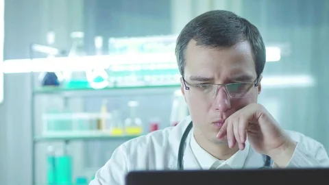 Serious concentrated doctor working at a computer in the laboratory Stock Footage 82973902