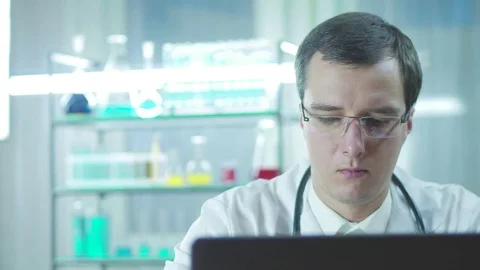 Serious concentrated doctor working at a computer in the laboratory Stock Footage 82974171