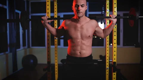 Serious concentrated man weight lifting with barbell in gym Stock Footage 145758475