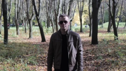 Serious confident man going and looking at camera in outdoors surrounding, close Stock Footage 81369700